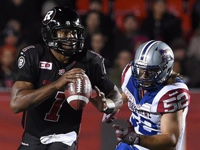 Ottawa Redblacks' Henry Burris looks for a pass as Montreal Alouettes' Nicolas Boulay runs towards him during third quarter CFL action in Ottawa on Thursday, Oct 1, 2015.