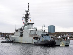 HMCS Athabaskan is guided by tugboats as it returns to Halifax, in this file shot from 2014.