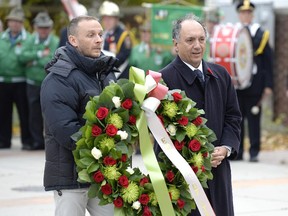 Italian Ambassador Gian Lorenzo Cornado, right, is accompanied by a Carabinieri as he places a wreath at the Piazza Dante during a memorial service for Cpl. Nathan Cirillo by members of the Ottawa's Italian Canadian community on Sunday.