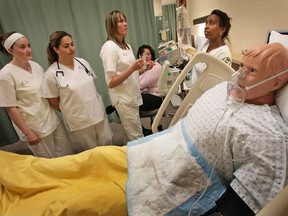 University of Manitoba nursing students practise injecting drugs into an IV drip.