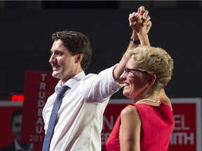 Justin Trudeau has promised to work with the premiers on climate change. He's shown here with Ontario Premier Kathleen Wynne.