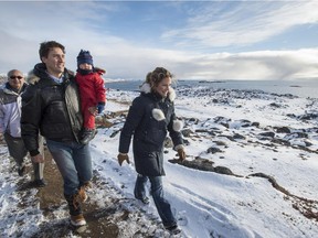Liberal leader Justin Trudeau, holding his son Hadrien, walks along the shores of Frobisher Bay with his wife Sophie Saturday, October 10, 2015 in Iqaluit.