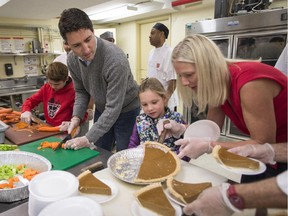 Ottawa Centre candidate Catherine McKenna helps Justin Trudeau's daughter, Ella-Grace, cut pumpkin pie while the Liberal leader and his son, Xavier, cut vegetables on Sunday, Oct. 11, 2015.
