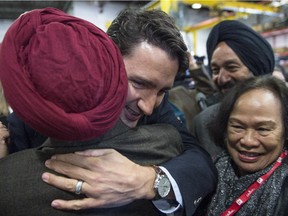 Liberal Leader Justin Trudeau embraces a supporter after speaking during a campaign stop at a forklift dealership in Montreal, Thursday, October 1, 2015.