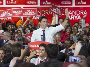 Liberal Leader Justin Trudeau waves to supporters from the podium during a campaign stop at a riding office Monday, October 12, 2015 in Ottawa.