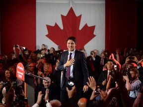 Liberal leader Justin Trudeau puts his hand on his heart as he arrives to Liberal election headquarters in Montreal, Que. on Monday, October 20, 2015.