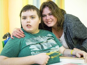 Lisa Barrie, right, snuggles up to her son, Jeffrey Michaud, in his hospital room at CHEO in late October. The Carleton Place boy, who suffered two strokes in his sleep last July while unknowingly infected with bacterial meningitis, is off his feeding tube, has started saying, 'Hi' to his mother and is taking up to five steps at a time, according to a volunteer group raising money for Jeffrey and his family.