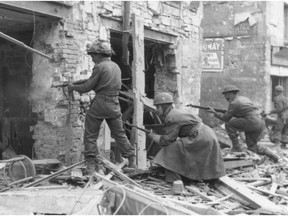 Canadian soldiers fire into a battered house during the Battle for Caen, France, June 10, 1944.