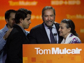 NDP leader Tom Mulcair is surrounded by his wife Catherine Pinhas and sons Matt and Greg, 2nd from left, after delivering a speech to party supporters in Montreal on Monday October 19, 2015.