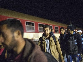Migrants and refugees board a train, after crossing the Greek-Macedonian border, near Gevgelija on October 6, 2015. Macedonia is a key transit country in the Balkans migration route into the European Union, with thousands of asylum seekers and migrants - many of them from Syria, Afghanistan, Iraq and Somalia - entering the country every day. The EU said a controversial programme to relocate 40,000 refugees within the bloc from overstretched frontline states would formally start on October 9 when a group of Eritreans will travel to Sweden from Italy.