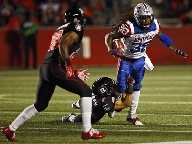 Ottawa Redblacks' Antoine Purneau, 6, gets his hands on Montreal Alouettes' Dominique Ellis, while Redblacks Brandyn Thompson, 25, looks on during the first half.