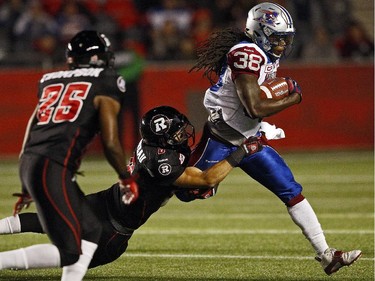 Ottawa Redblacks' Antoine Purneau, 6, gets his hands on Montreal Allouetes' Dominique Ellis, while Redblacks Brandyn Thompson, 25, looks on during the first half.