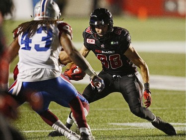 Ottawa Redblacks' Brad Sinopoli, 88, eludes the tackle of Montreal Alouettes' Terry Johnson, 43, during the first half.