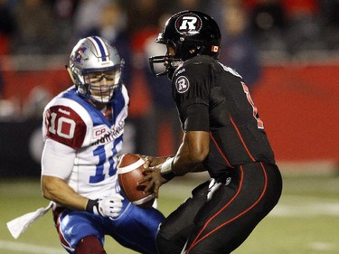 Ottawa Redblacks' QB Henry Burris, 1, is pursued by Montreal Alouettes' Marc-Olivier Brouillette, 10, during the first half.