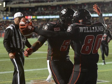 Ottawa Redblacks teammates Ernest Jackson and Chris Williams celebrate Williams' touchdown against the Montreal Alouettes during first half CFL action.