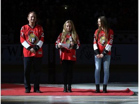 Ottawa Senators owner Eugene Melnyk stands at centre ice with his daughters Olivia and Anna before a Senators game in 2015.