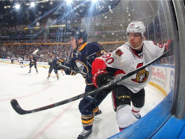 Mark Pysyk #3 of the Buffalo Sabres battles along the boards against Alex Chiasson #90 of the Ottawa Senators.