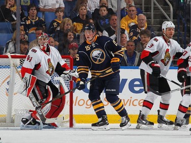 Jack Eichel #15 of the Buffalo Sabres battles for position in between Craig Anderson #41 and Marc Methot #3 of the Ottawa Senators.