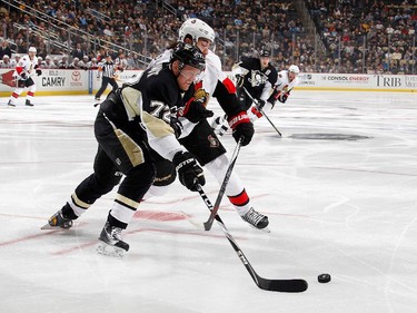 Patric Hornqvist #72 of the Pittsburgh Penguins moves the puck in front of Mika Zibanejad #93 of the Ottawa Senators.
