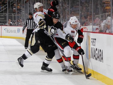 Kevin Porter #11 of the Pittsburgh Penguins battles for the puck between the defense of Cody Ceci #5 and Alex Chiasson #90 of the Ottawa Senators.