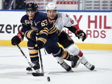 Tyler Ennis #63 of the Buffalo Sabres battles for the puck against Mike Hoffman #68 of the Ottawa Senators.