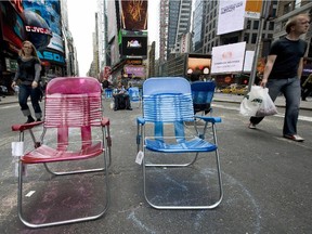 Pedestrians walk past lawn chairs on a section of Broadway closed to cars in Times Square on May 26, 2009 in New York.