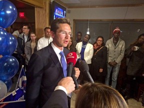 Pierre Poilievre talks to supporters Monday night as it appeared he hung on in the new riding of Carleton.