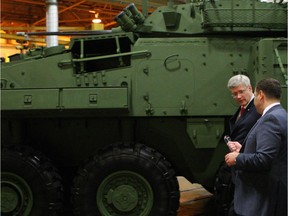 Prime Minister Stephen Harper tours the General Dynamics Land Systems - Canada plant, next to a LAV 6.0 (Light Armoured Vehicle) being built for Canada, at the facility in London, Ont., Friday, May 2, 2014.