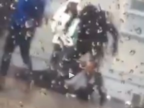 A still image taken from a video that shows  an Ottawa police officer punching a man in the face in front of the Salvation Army on George Street.