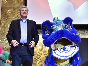 Conservative Leader Stephen Harper looks on beside a Chinese dragon costume during a campaign stop in Richmond Hill, Ont., on Tuesday, Sept. 29, 2015.
