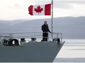 Prime Minister Stephen Harper stands on the bow of the HMCS Kingston as it sails in the Navy Board Inlet in August 2014.