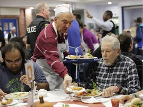Steve Georgopoulos, a volunteer at The Ottawa Mission for more than 20 years, serves meals during the annual Thanksgiving Holiday Dinner on Monday, Oct. 12, 2015.
