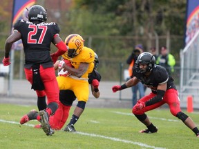 Carleton Ravens defenders converge on a Queen's ball carrier on Saturday, Oct. 31, 2015 in Kingston.