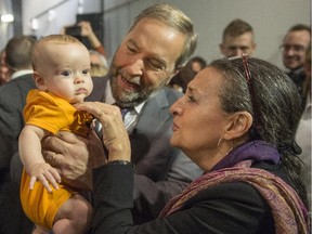 NDP Leader Tom Mulcair and his wife Catherine, say hello to four-month-old Penelope Nicholls, after a town hall meeting Friday in Montreal.