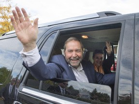 NDP Leader Tom Mulcair and his wife, Catherine, wave from their car after a rally Tuesday, October 6, 2015 in Surrey, B.C.
