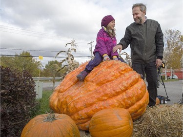 NDP leader Tom Mulcair and his granddaughter, Juliette, play on a giant pumpkin while visiting a farm Wednesday, October 14, 2015 in L'Assomption, Que.