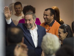 NDP Leader Tom Mulcair, accompanied by wife Catherine Pinhas, right, waves to supporters as he makes a campaign stop in Montreal on Thursday, Oct. 1, 2015.