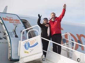NDP Leader Tom Mulcair and his wife Catherine wave as they depart Iqaluit, Nunavut after a campaign stop on Wednesday, Sept. 30, 2015.
