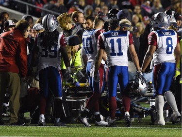 Training staffs attend to the Montreal Alouettes' Jonathan Hefney after a helmet-on-helmet collision with the Ottawa Redblacks' Patrick Lavoie.