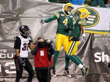 Adarius Bowman #4 and Derel Walker #87 of the Edmonton Eskimos celebrate after Bowman scored a touchdown during first half of Grey Cup 103 in front of Kienan Lafrance #37 of the Ottawa Redblacks at Investors Group Field on November 29, 2015 in Winnipeg, Manitoba, Canada.