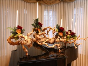 Bouquets of red roses, cedar, reindeer moss, magnolia leaves and sliced pomegranate, the latter a symbol of abundance and tradition in Armenia, are grouped on a massive century-old, sandblasted grape vine that sits atop the piano.