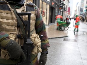 A Belgian Army soldier patrols an otherwise busy shopping street in Brussels on Saturday, Nov. 21, 2015. Belgium raised its security level to its highest degree on Saturday as the manhunt continues for extremist Salah Abdeslam who took part in the Paris attacks. The security levels shut down all metro lines and shuttered many shops as well as cancelling sports matches.