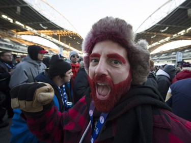 A football fan smiles for a photo as he attends the 103rd Grey Cup between the Edmonton Eskimos and the Ottawa Redblacks in Winnipeg, Man., on Sunday, Nov. 29, 2015.