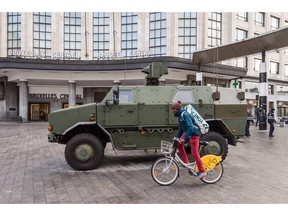 A man cycles by Belgian Army vehicle parked in front of the main train station in the center of Brussels on Sunday, Nov. 22, 2015.Western leaders stepped up the rhetoric against the Islamic State group on Sunday as residents of the Belgian capital awoke to largely empty streets and the city entered its second day under the highest threat level. With a menace of Paris-style attacks against Brussels and a missing suspect in the deadly Nov. 13 attacks in France last spotted crossing into Belgium, the city kept subways and underground trams closed for a second day.
