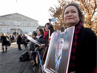 A member of the public holds a Justin Trudeau campaign poster before the swearing-in ceremony of Prime Minister-designate Justin Trudeau at Rideau Hall in Ottawa on Wednesday, Nov. 4, 2015.