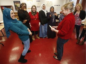 Advanced English class student, Soukaina Oleik, left, has a laugh with her teacher, Brenda Windmill, right, at a school run by the Ottawa Community Immigrant Services Organization. Settlement agencies say they'll need more money for teachers, counsellors and other to help the wave of Syrian refugees about to arrive in Ottawa.