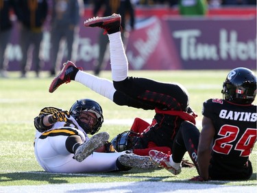 Andy Fantuz of the Hamilton Tiger-Cats is tackled by Abdul Kanneh and Jerrell Gavins (24) of the Ottawa Redblacks during first half of the East Conference finals at TD Place in Ottawa, November 22, 2015. (Jean Levac/ Ottawa Citizen)