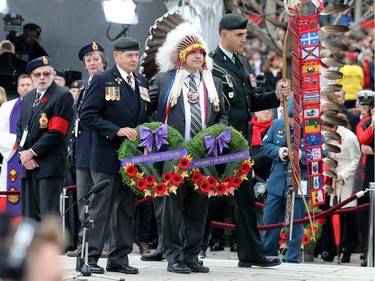 Assembly of First Nations Chief Perry Bellegarde (C) is one of many groups to lay a wreath as the National Remembrance Day Ceremony takes place at the National War Memorial in Ottawa.