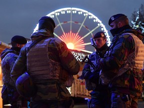 Belgian soldiers patrol during the opening night of the annual Christmas market on November 27, 2015 in Brussels. Belgium reduced the terrorism alert in Brussels from its highest possible level on November 26 after Prime Minister Charles Michel said the threat of a Paris-style jihadist attack was no longer as imminent.
