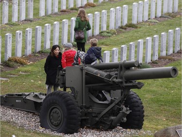Children play atop an old gun after the Remembrance Day ceremony at the National Military Cemetery on the grounds of the Beechwood Cemetery Wednesday November 11, 2015.